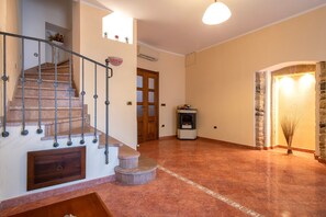 A staircase with a handrail, a fireplace, and a stone wall. - Bed and Breakfast 'Camera Matrimoniale Superior' with Mountain View, Garden and Air Conditioning (Giave)
