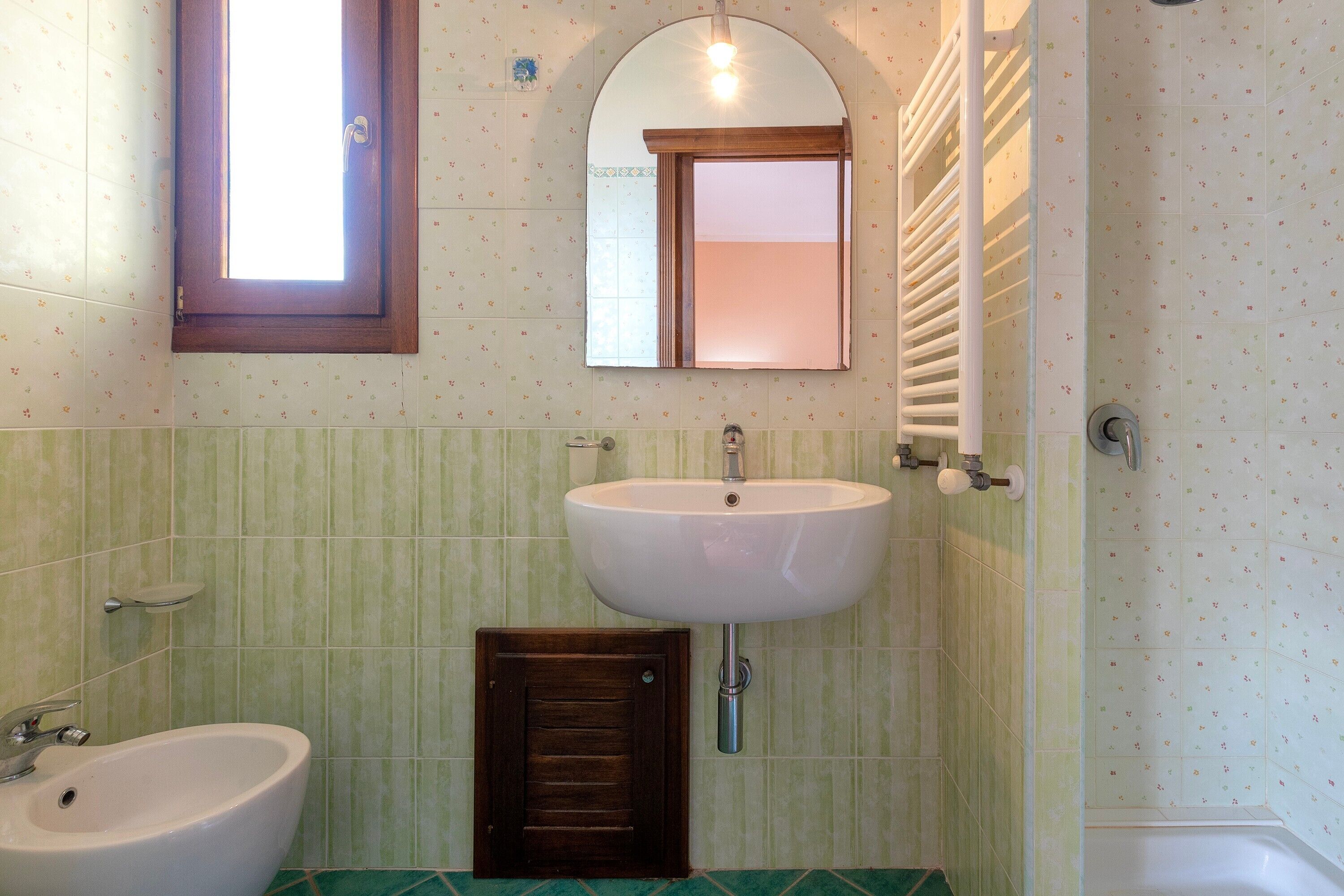 Un bagno con lavandino, specchio e doccia.