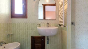 Un bagno con lavandino, specchio e doccia.