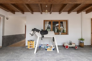 A room with a wooden ceiling, a window with curtains, a small table, a toy car, and a potted plant. - Room 'Doble - 1' with Mountain View, Wi-Fi and Air Conditioning (Santa Eulària des Riu)