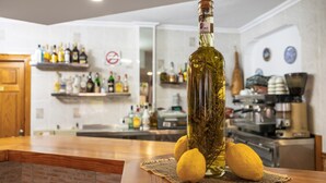 Uma bancada de cozinha com um frasco de azeite, limões e um jogo americano de tecido.