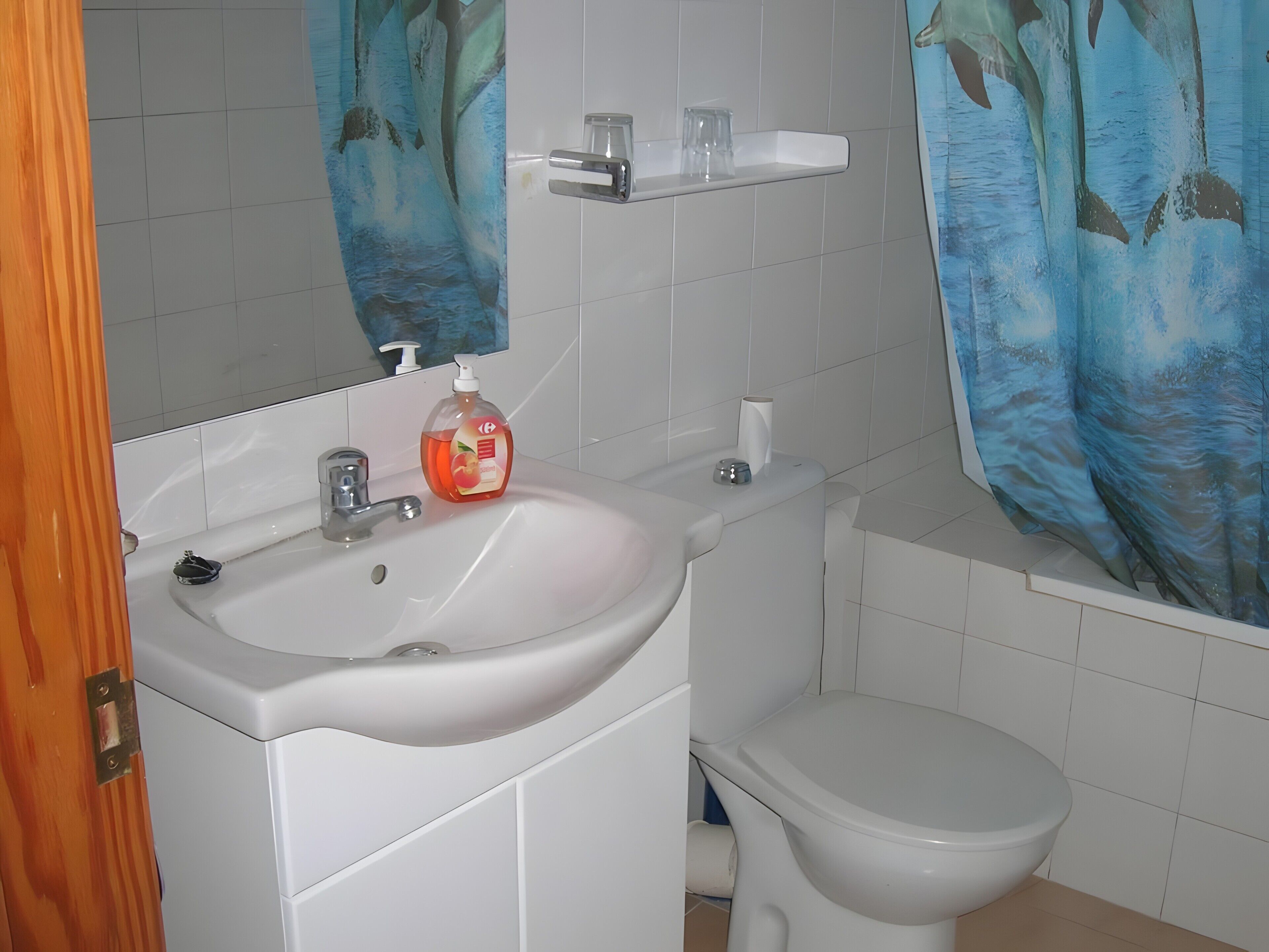 A bathroom with a white sink, a toilet, and a mirror above the sink.