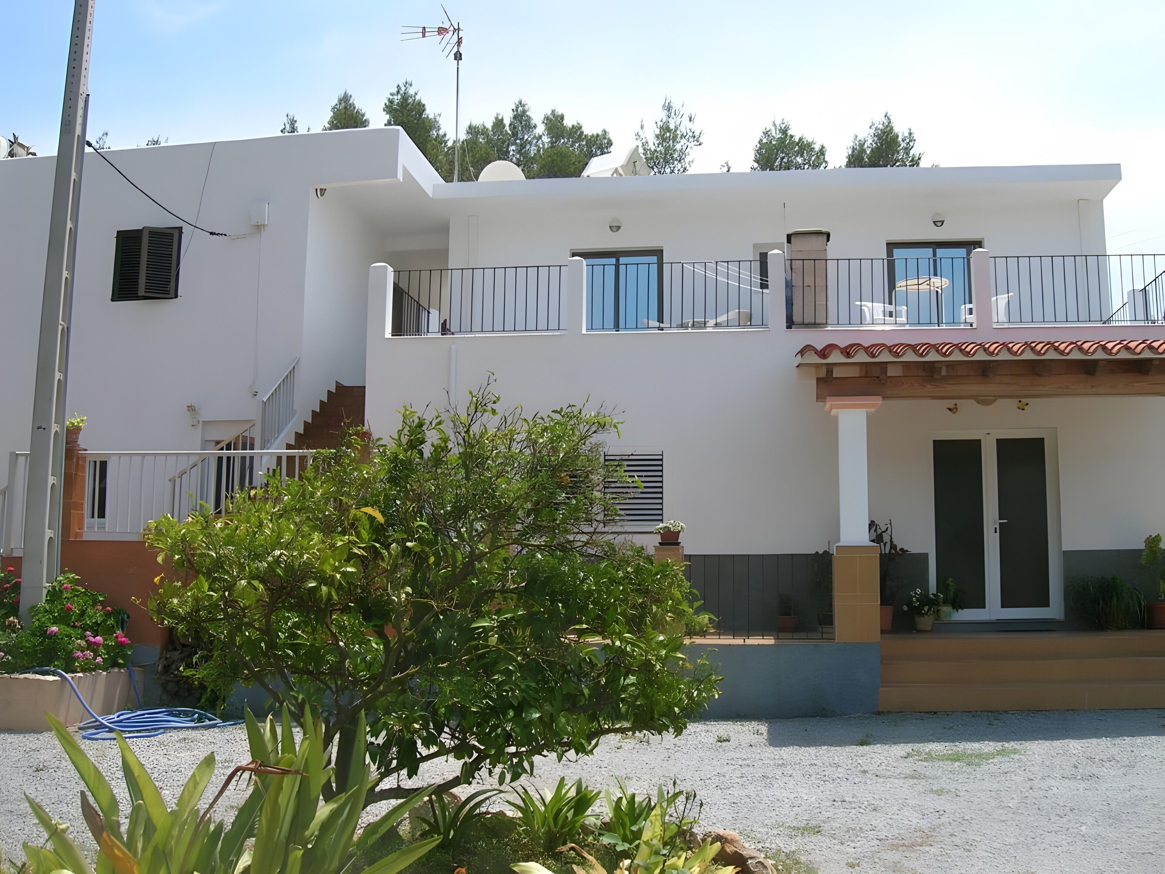 A two-story building with a balcony, a staircase, and a door.
