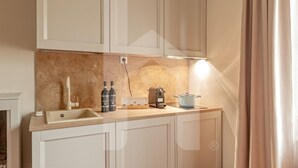 A modern kitchen with a beige countertop, a sink, a coffee maker, and a blue pot.