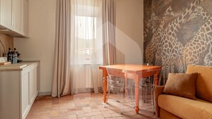 A room with a wooden table, clear chairs, a beige sofa, and a giraffe mural on the wall.