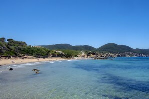 A coastal beach with clear water, rocky outcrops, and a hilly backdrop. - Room 'Doble - 6' with Mountain View, Wi-Fi and Air Conditioning (Santa Eulària des Riu)