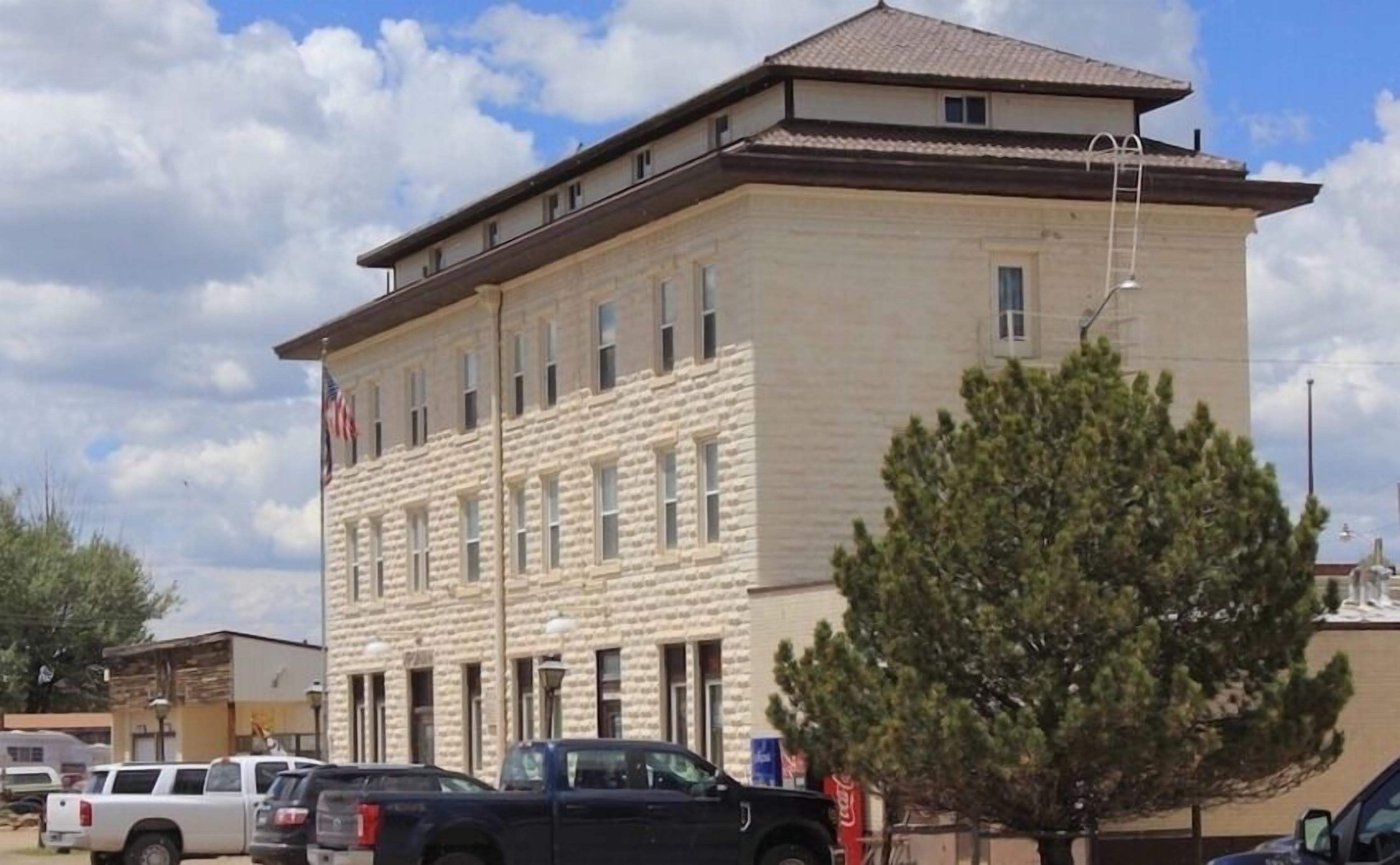 A two-story building with a stone facade and multiple windows.