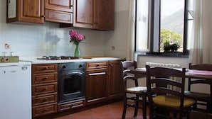 Une cuisine avec des meubles de rangement en bois, une cuisinière, un réfrigérateur et une fenêtre donnant sur un beau paysage.