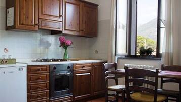 Kjøleskap, kokeplater, høy barnestol og kjøkkenutstyr