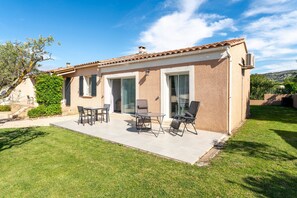 Una casa con patio, mobili da esterno e vista sul paesaggio circostante.