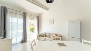 A modern room with a white table, chairs, a sofa, a whiteboard, and a window with curtains. - Holiday Home 'Chez Céline' with Private Pool, Wi-Fi and Air Conditioning (Aubignan)