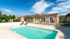 A swimming pool with a tiled deck, a fenced patio area, and a house with a tiled roof. - Holiday Home 'Chez Céline' with Private Pool, Wi-Fi and Air Conditioning (Aubignan)