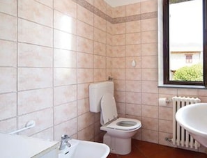 A bathroom with a toilet, sink, and bathtub.