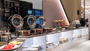 A buffet setup with various food items and utensils. - THE MUSTEL HOTEL CHONGQING. HONGYADONG (Chongqing)