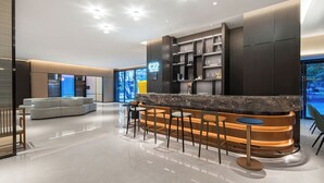 A modern lobby with a reception desk, seating area, and a large window. - THE MUSTEL HOTEL CHONGQING. HONGYADONG (Chongqing)