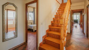Una escalera de madera con escalones y barandal, que conduce a un piso superior.