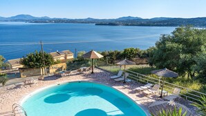 A swimming pool with a clear view of the sea and mountains in the background. - Apartment 'Stefanos Place Sea View' with Sea View, Wi-Fi and Air Conditioning (Corfu)