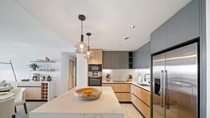 Een moderne keuken met een centraal eiland, roestvrijstalen apparatuur en een minimalistisch design.