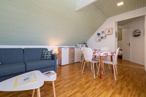 A modern, compact living space with a dining area, kitchenette, and a cozy seating area.