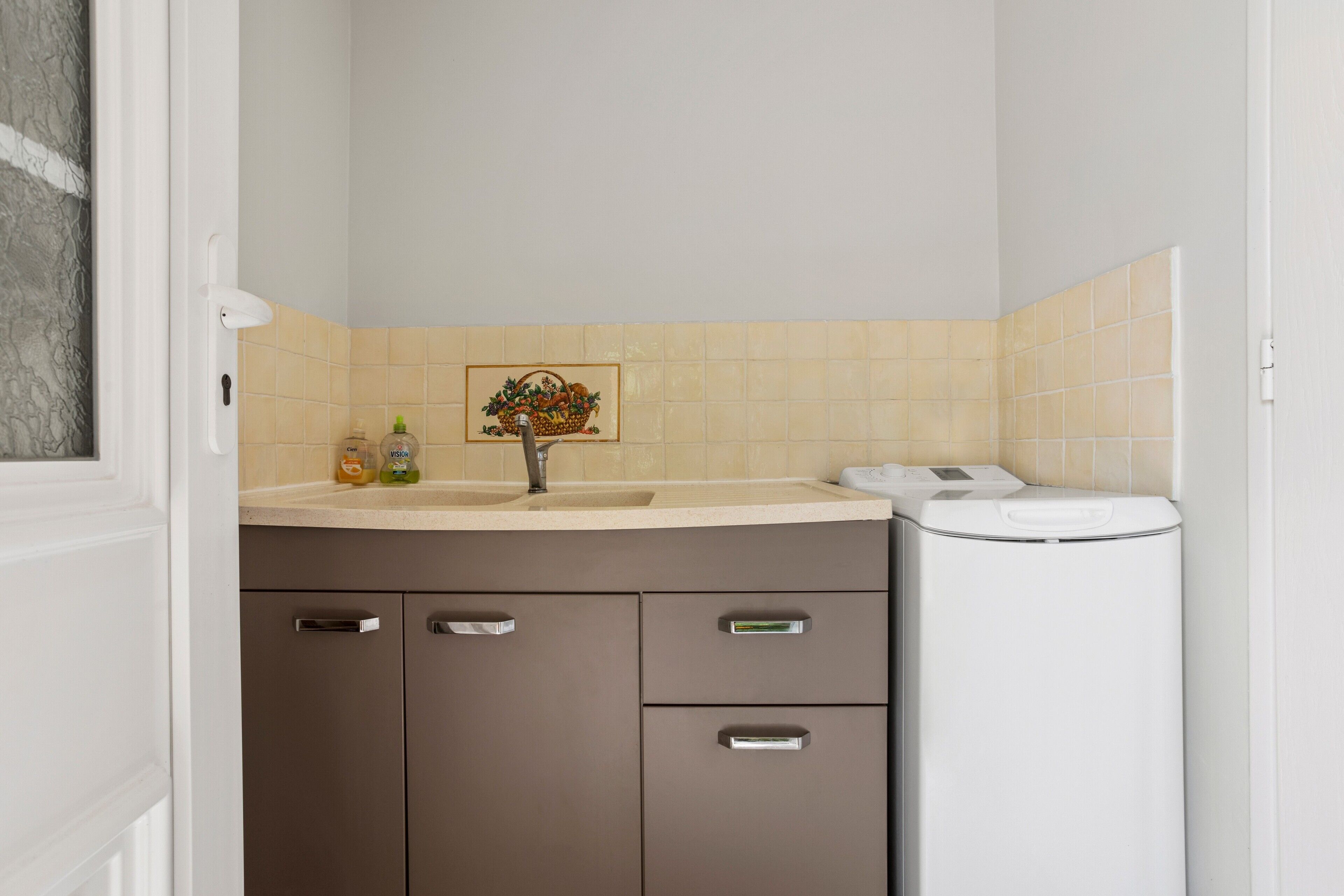 Une salle de bain avec un lavabo, des toilettes et des placards.