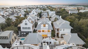 Un quartier résidentiel situé sur la côte, composé de plusieurs maisons, dont certaines sont dotées de balcons et d’un petit espace piscine.