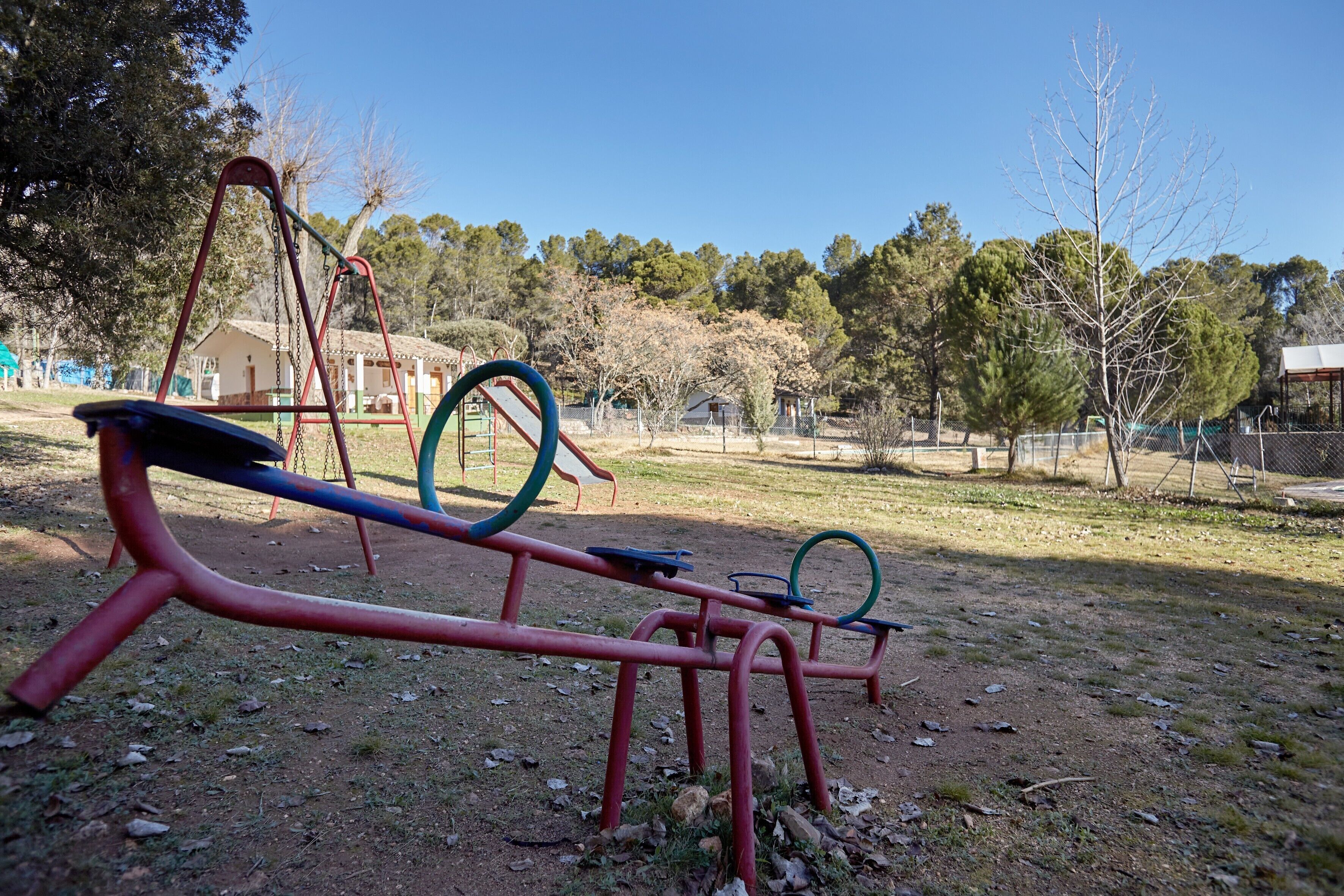 Un espace extérieur aménagé pour faire de l’exercice, avec des équipements, des arbres et un ciel dégagé.