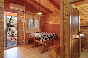 Ein rustikales Holzhaus-Interieur mit Tisch, Bank und Spüle.