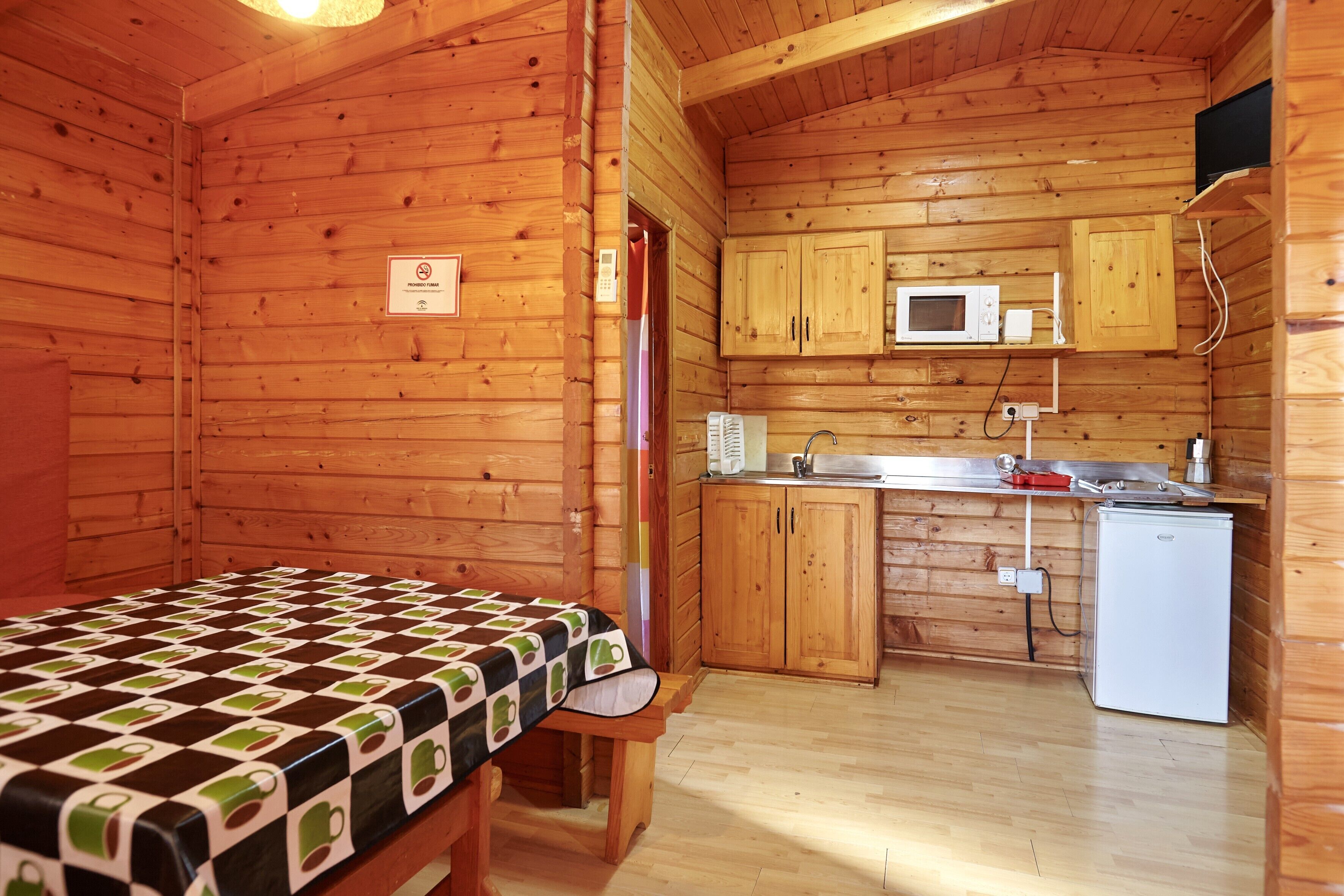 A cabin with a bed, a kitchenette, and a microwave.