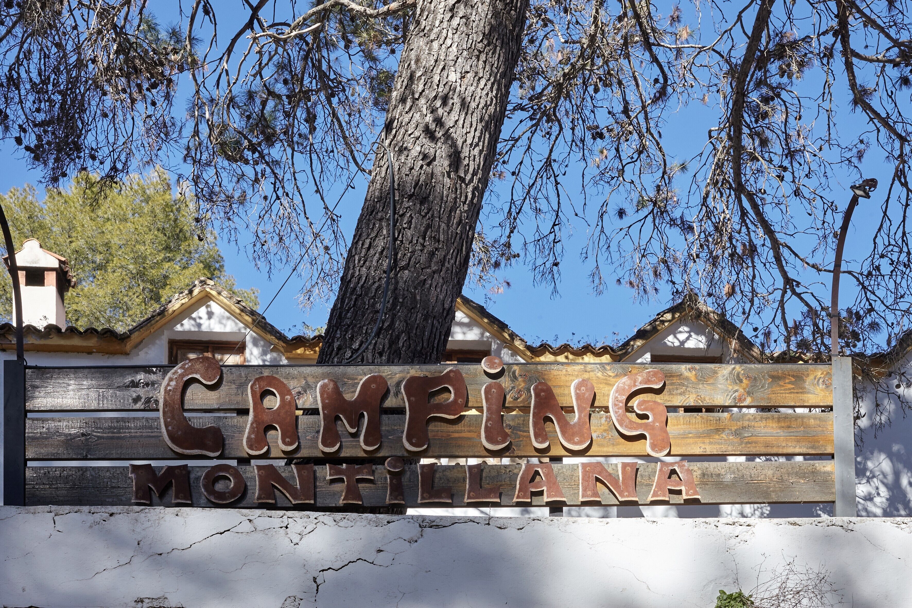 A wooden sign with the text 'CAMING MONTILLANA' indicating a location.