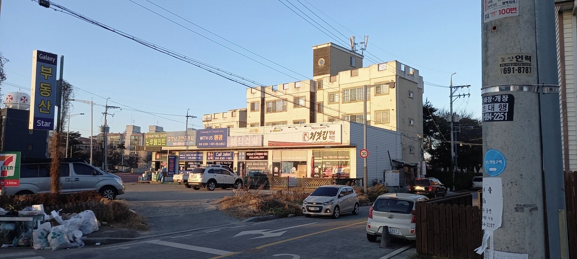 Un immeuble à plusieurs étages abritant divers commerces, notamment un atelier de peinture et une entreprise de nettoyage.
