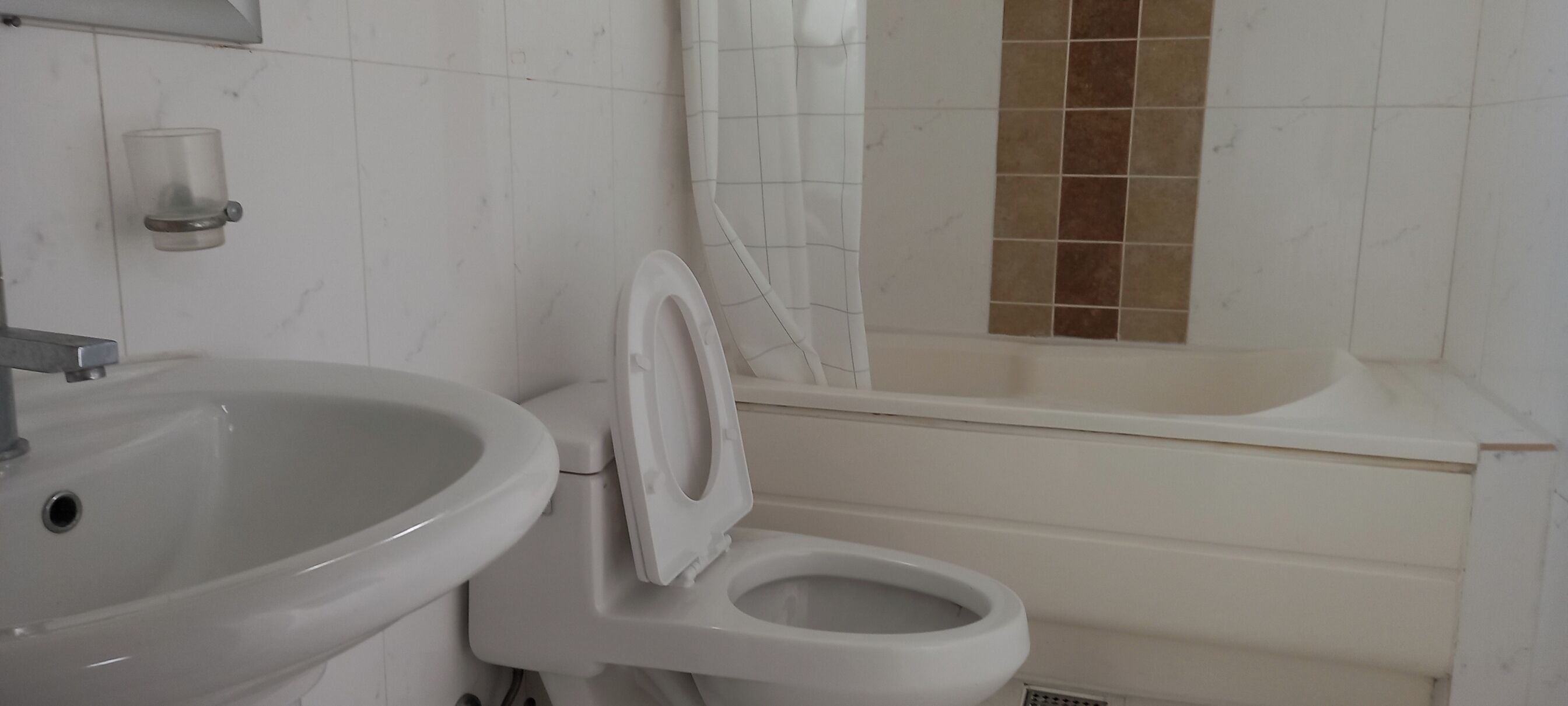 Un baño con inodoro, lavamanos y bañera.