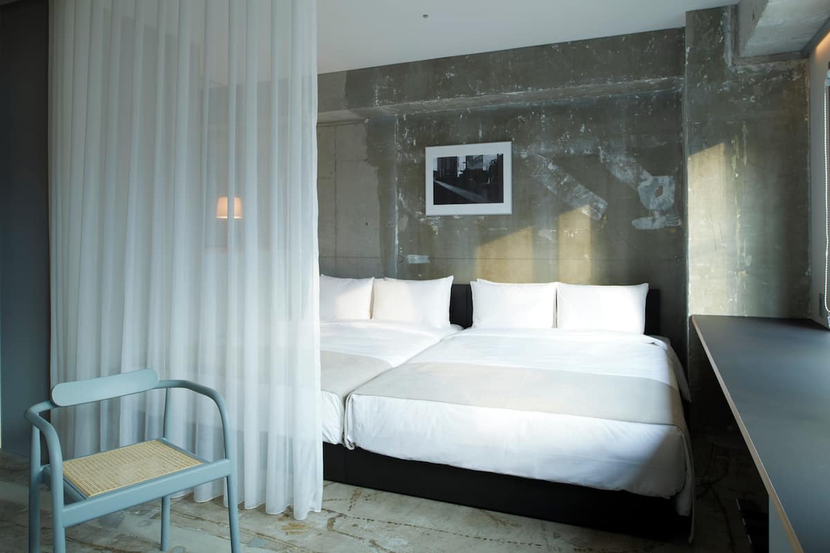 A bedroom with a bed, a chair, and a desk.