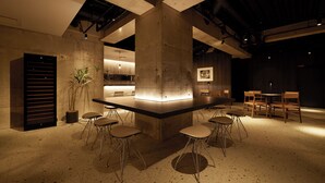 Ein modernes Interieur mit einer zentralen Bar, Sitzgelegenheiten und einer Topfpflanze.