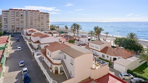 Une zone résidentielle côtière avec des bâtiments blancs, une plage et un grand hôtel.