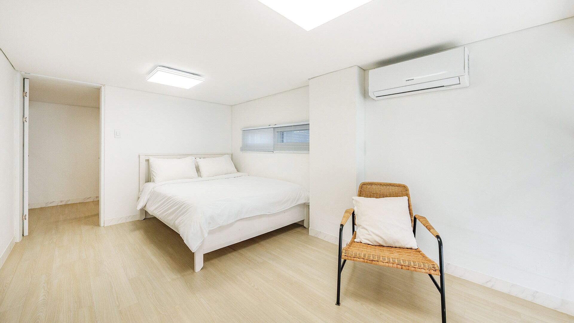 Quarto com uma cama, uma cadeira, uma janela e um ar condicionado.