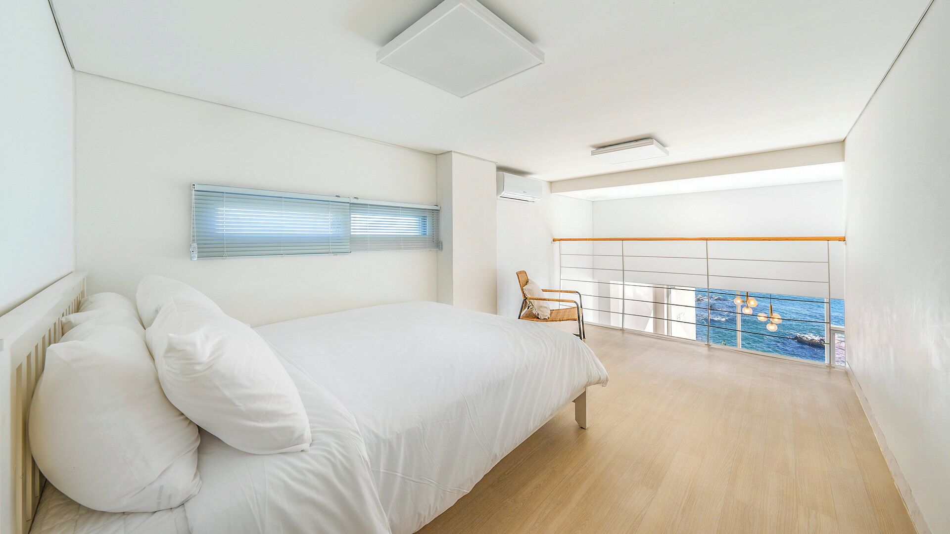 Un dormitorio con cama, una silla y un balcón con vistas.