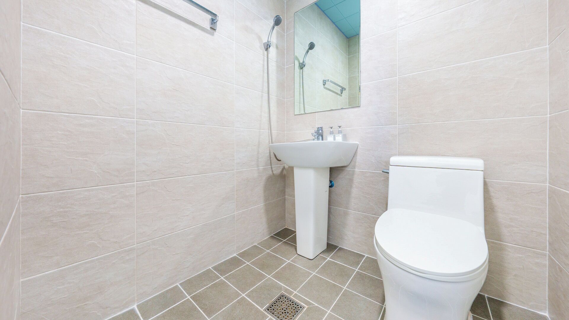 Un baño con inodoro, lavamanos y ducha.
