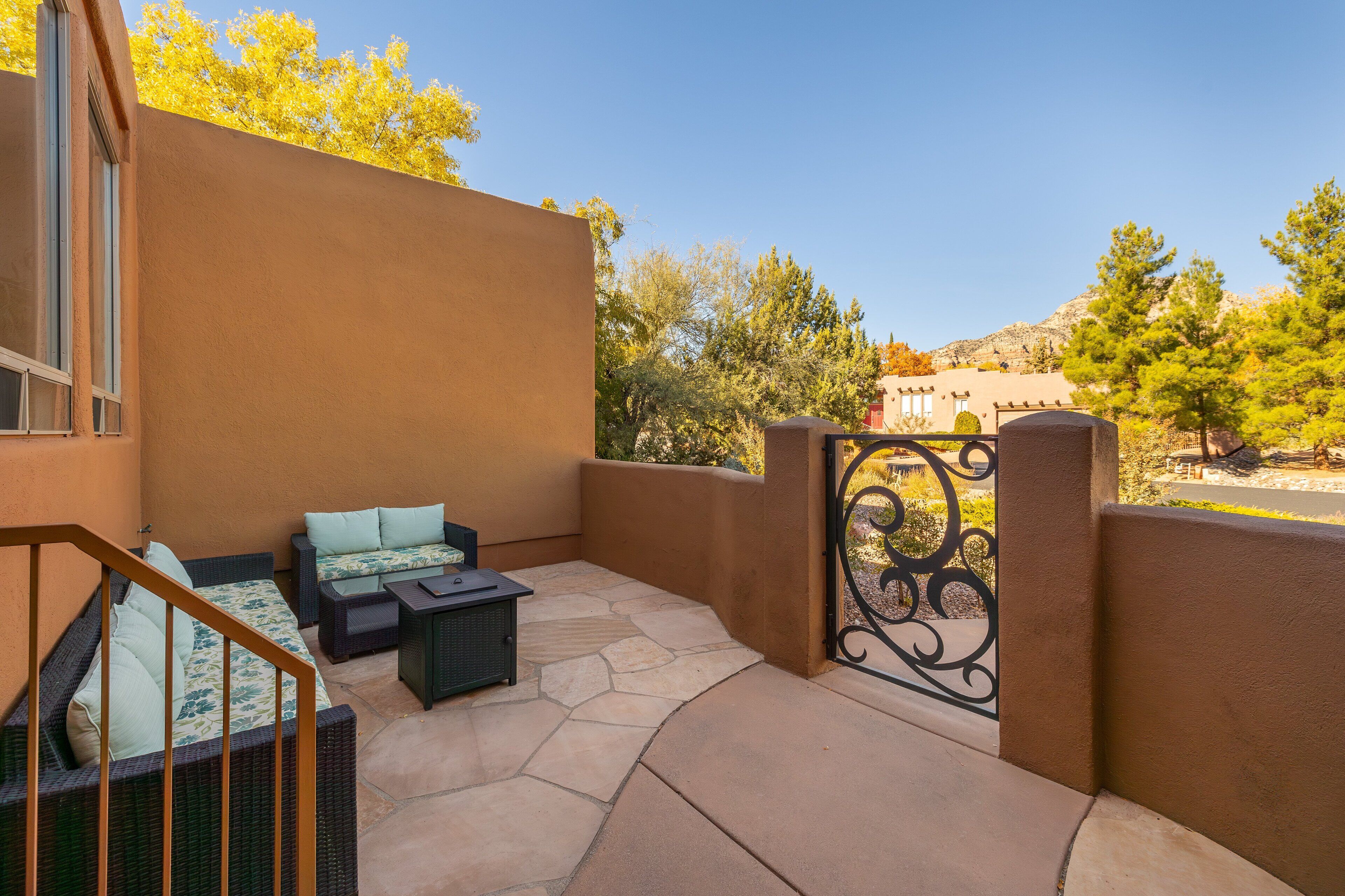 A patio area with a sofa, a small table, and a staircase.