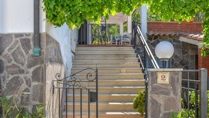 A stone staircase leading to a covered area with a metal gate and a number sign indicating room 2. - Holiday Home 'Innamorata Mare' with Sea View, Private Terrace and Wi-Fi (Capoliveri)