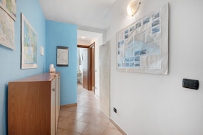 Un pasillo con un escritorio de madera, un mapa en la pared y un tablón de anuncios.
