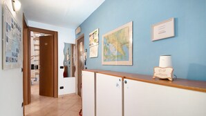 Un pasillo con un mostrador de recepción de madera, un mapa en la pared y una puerta que da a una habitación.