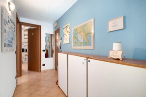 A hallway with a wooden reception desk, a map on the wall, and a door leading to a room.