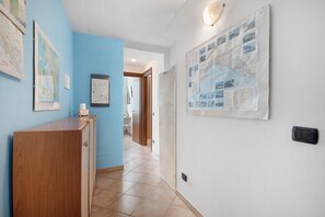 A hallway with a wooden desk, a map on the wall, and a bulletin board.