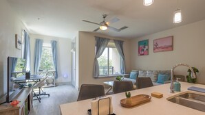 Cocina moderna con isla central, comedor y zona de estar con sofá y sillones.
