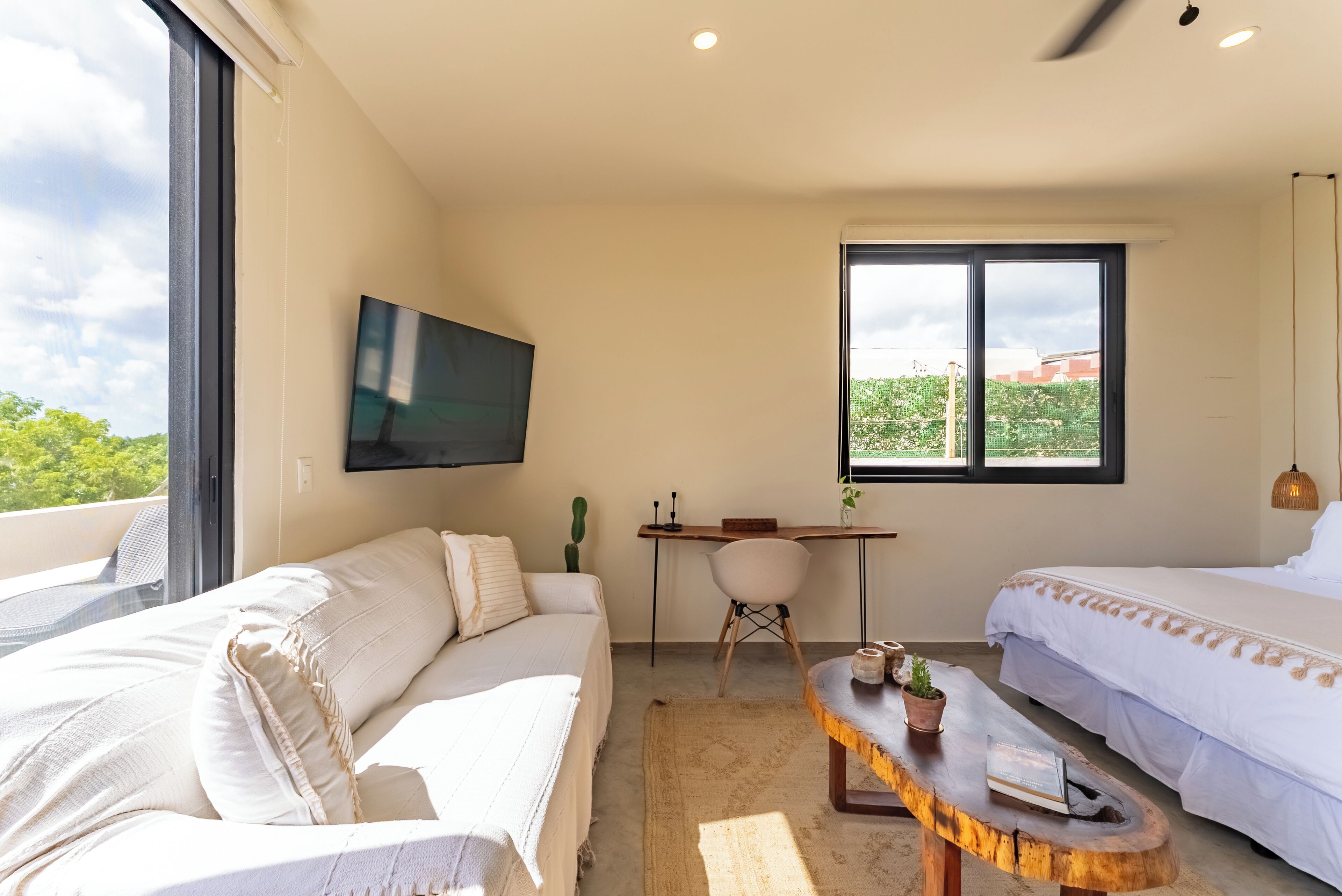 Una habitación de hotel moderna con una cama grande, un sofá, un escritorio y un televisor.
