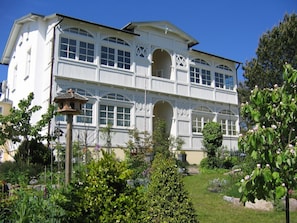 A two-story building with large windows and a garden in front. - Villa mit Sonnenhof - Your dream vacation in the vacation apartment Gartenzauber - Villa mit Sonnenhof (Göhren)