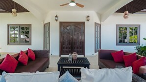 A spacious living area with two sofas, a coffee table, and a ceiling fan. - Kesorn Charming Authentic Thai Pool Villa Phuket (Rawai)