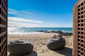 A beach view with two bean bags and a wooden fence. - Takapuna Beachfront w/Stunning Views (Auckland)