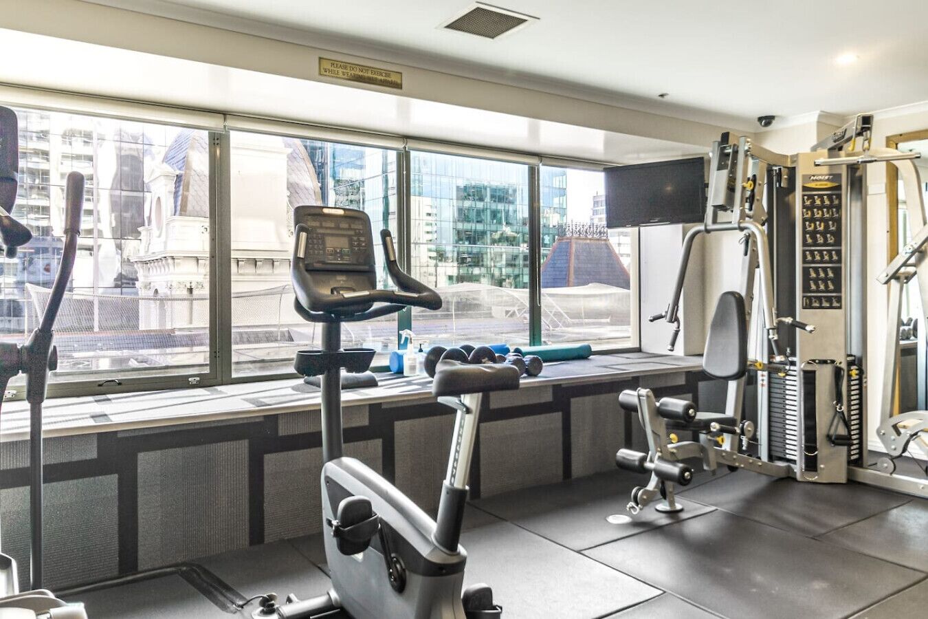 Une salle de sport équipée de machines d’exercice, d’un tapis de course et d’haltères.
