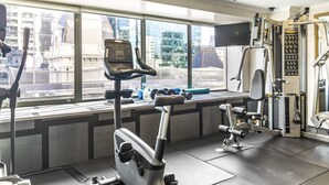 A gym with exercise equipment, a treadmill, and dumbbells.